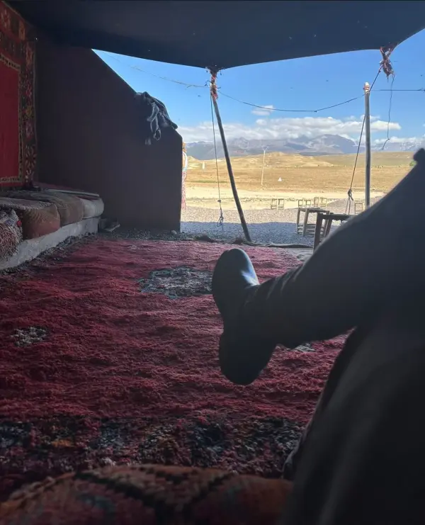 Vue depuis une tente berbère avec tapis rouge sur les montagnes de l’Atlas