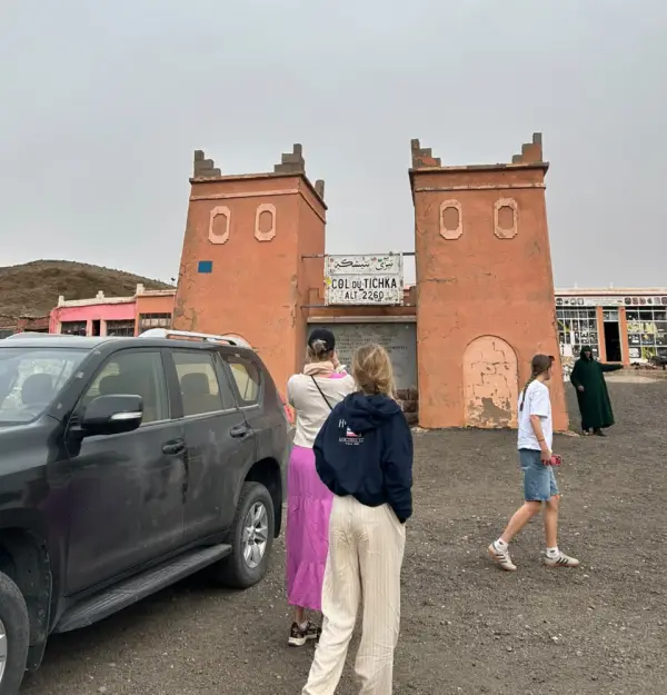 Voyageuses devant la porte du col du Tichka à côté d’un Prado