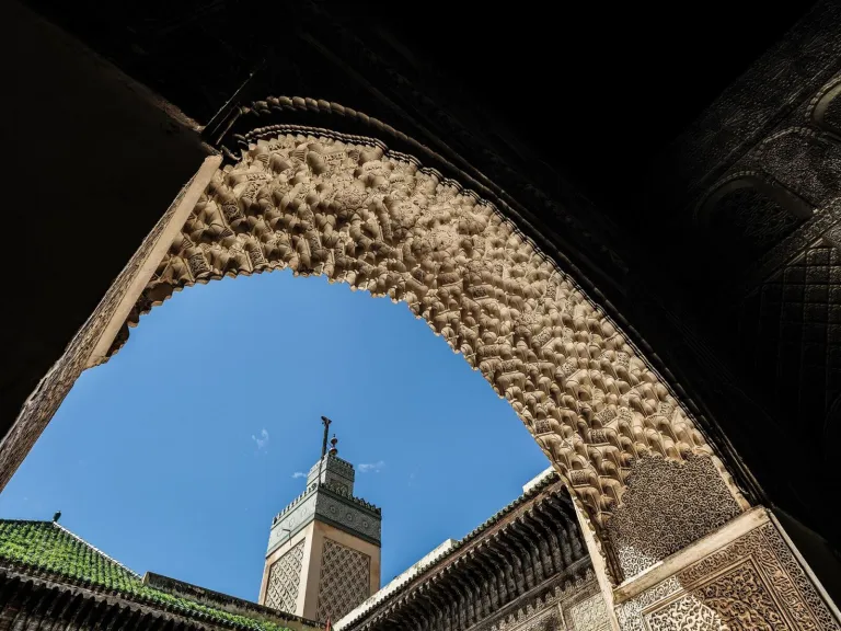 Arche sculptée et minaret à Fès